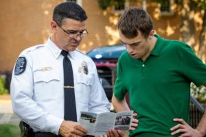 police officer and student reading a brochure