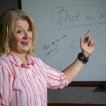 woman pointing at the whiteboard in an english program