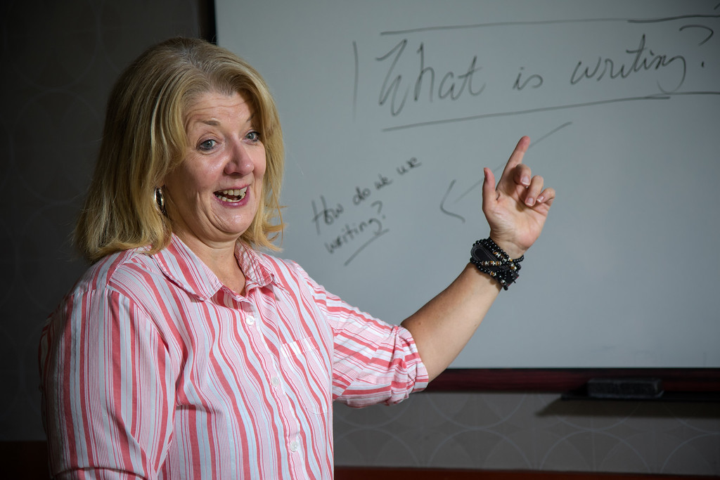 woman pointing at the whiteboard in an english program
