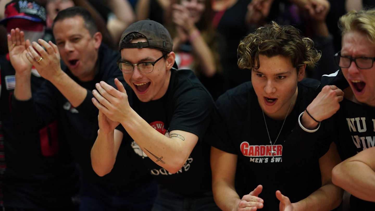 Group of enthusiastic students cheering at a basketball game