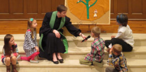 Allison Benfield talking with children in chapel