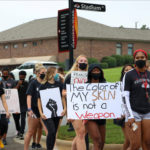 Students carry signs and march on campus