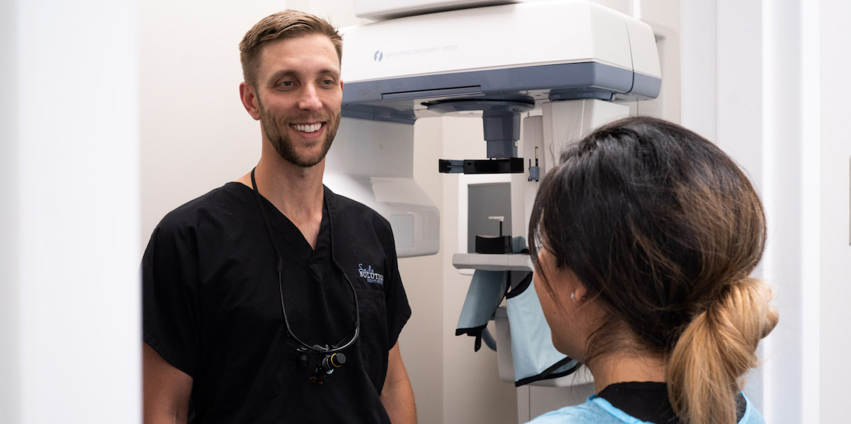 Dr. Trey Miller talks with a patient in his dental office