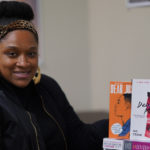 Dr. Kemeshia Swanson poses with some of the books she will be using in her African American Literature Course.
