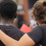 two students arm in arm in solidarity