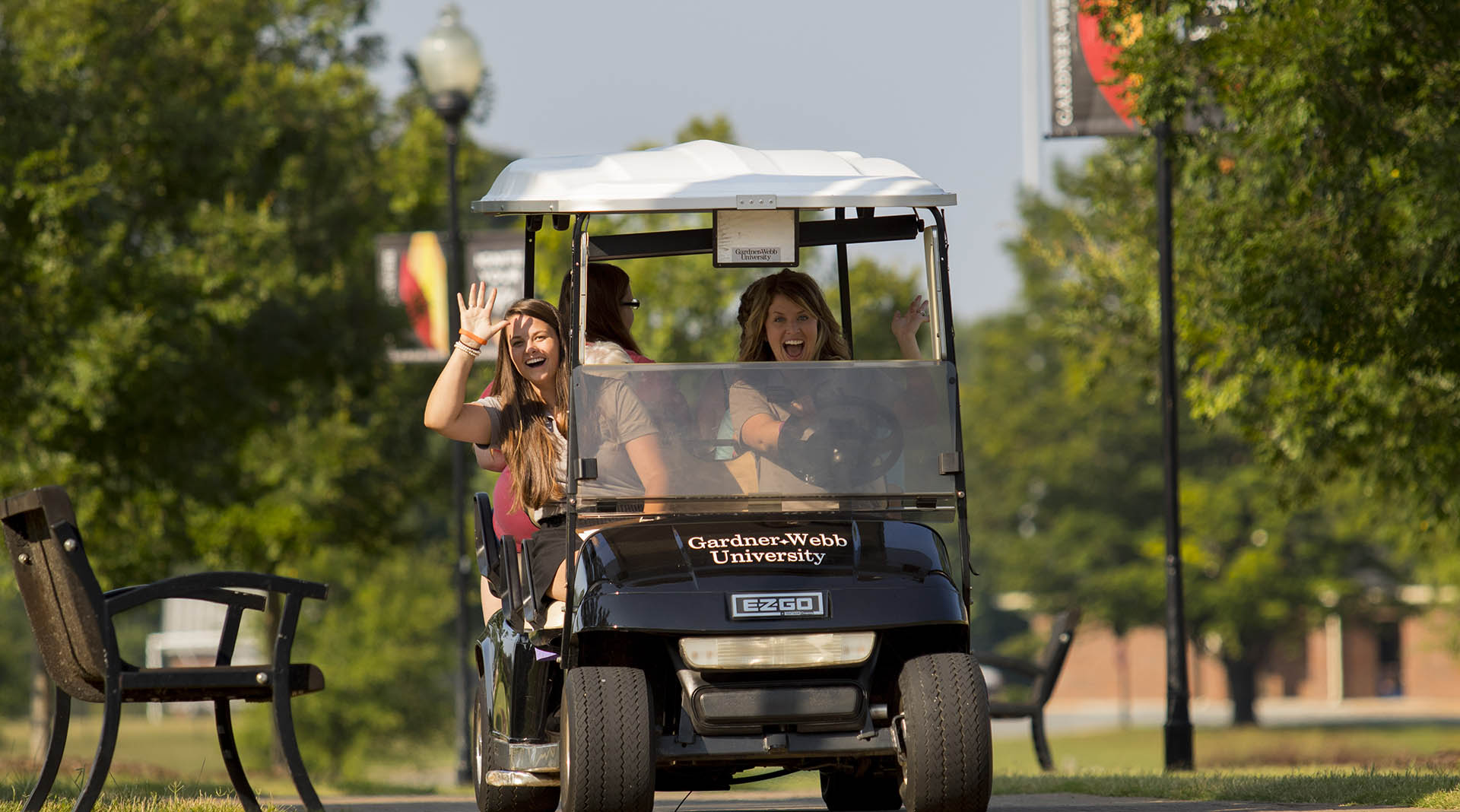 staff and students on golf cart doing campus tour