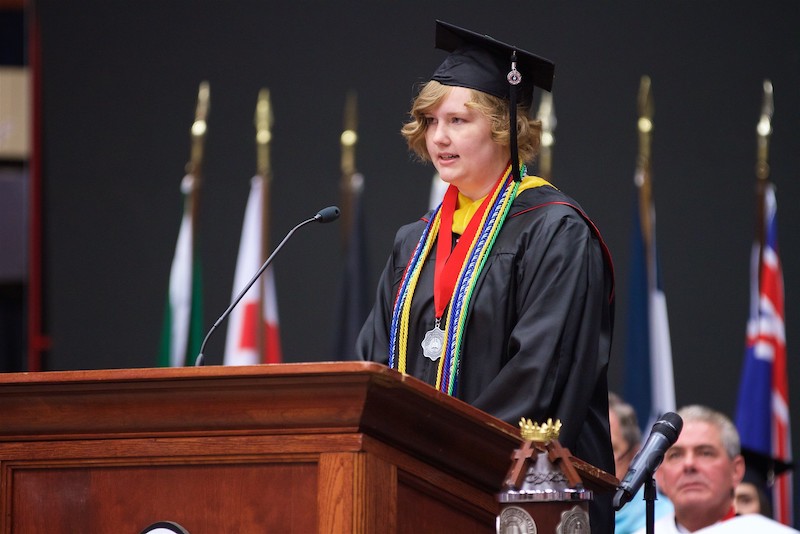 Juliette Ratchford stands at the podium to read the scripture during the Undergraduate commencement ceremony and graduation; Spring 2016, May 7, 10am.