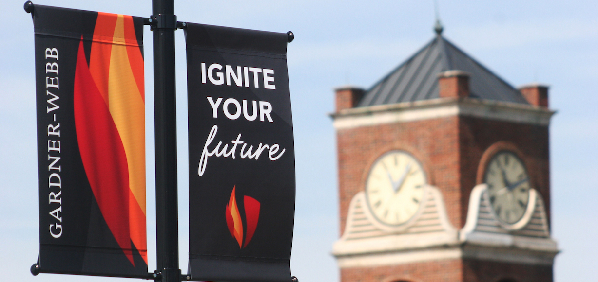 A photo of two Gardner-Webb Banners - one says Ignite Your Future and the other one features the flame logo