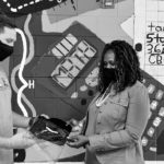 Matt Skeen, left, presents Chromebook covers to Jamila Brown, assistant principal of Mint Hill Middle School in Matthews, N.C., with Chris James, left, a principal intern at the school and board member of the Grey Foundation.