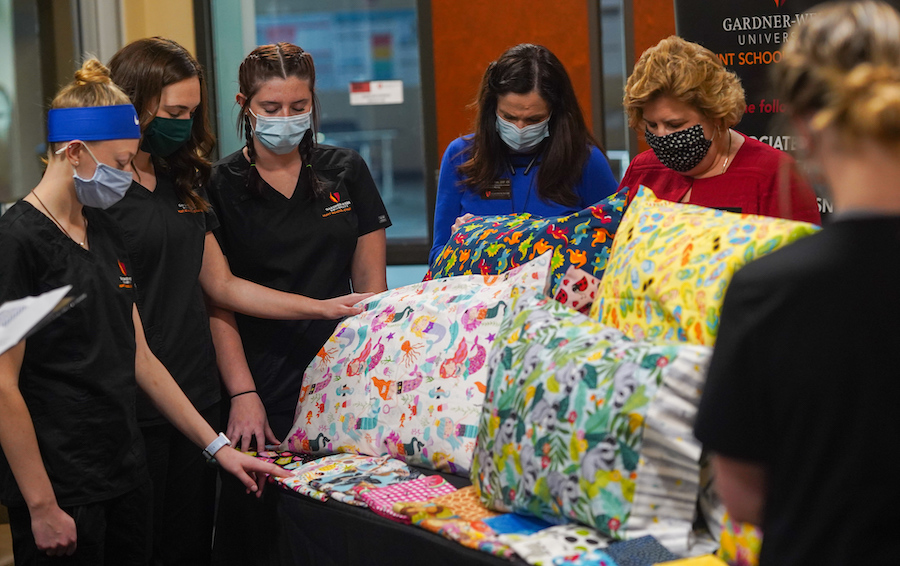 The nursingn students and Kim Downs pray over the pillowcases.