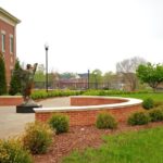 a campus shot of the angel statute with bell tower in background