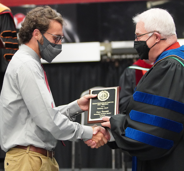 Dr. Mark Cole, right, presents an award to a student.