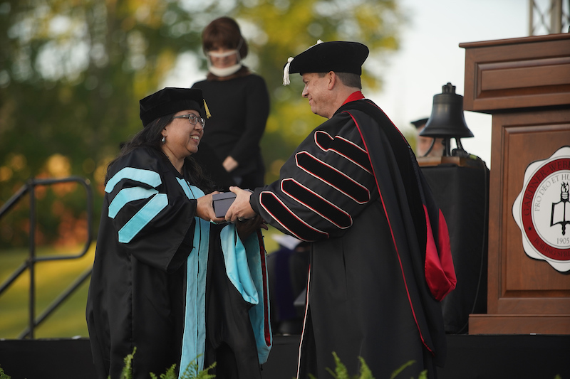 Dr. Mabel Lamprea, left, receives the Gravett Award from Dr. Downs at Commencement.t