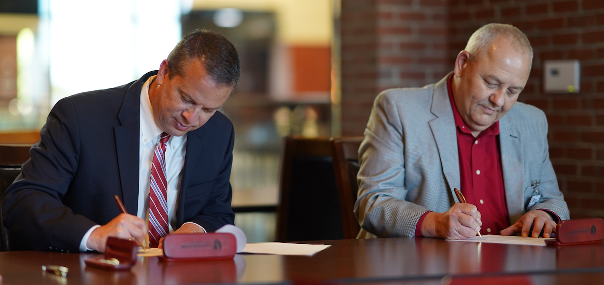 GWU President Dr. William M. Downs, left, and RichmondCC Vice President for Instruction Kevin Parsons sign the articulation agreement between the two institutions .