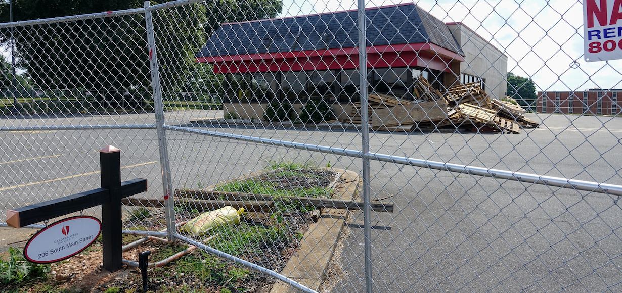 A photo showing the fence around the Hardee's which will be burned by the fire department. In the foreground is the GWU sign with the address of the property.