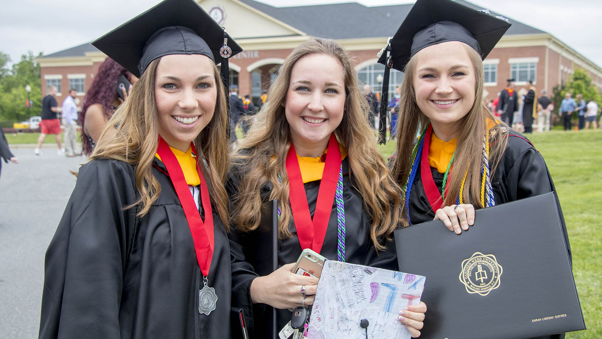 3 female students at undergraduate commencement
