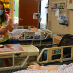 a student prepares to give a mannequin patient a vaccine