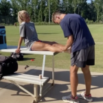 GWU Intern Luke Beamer tapes the ankle of a soccer player