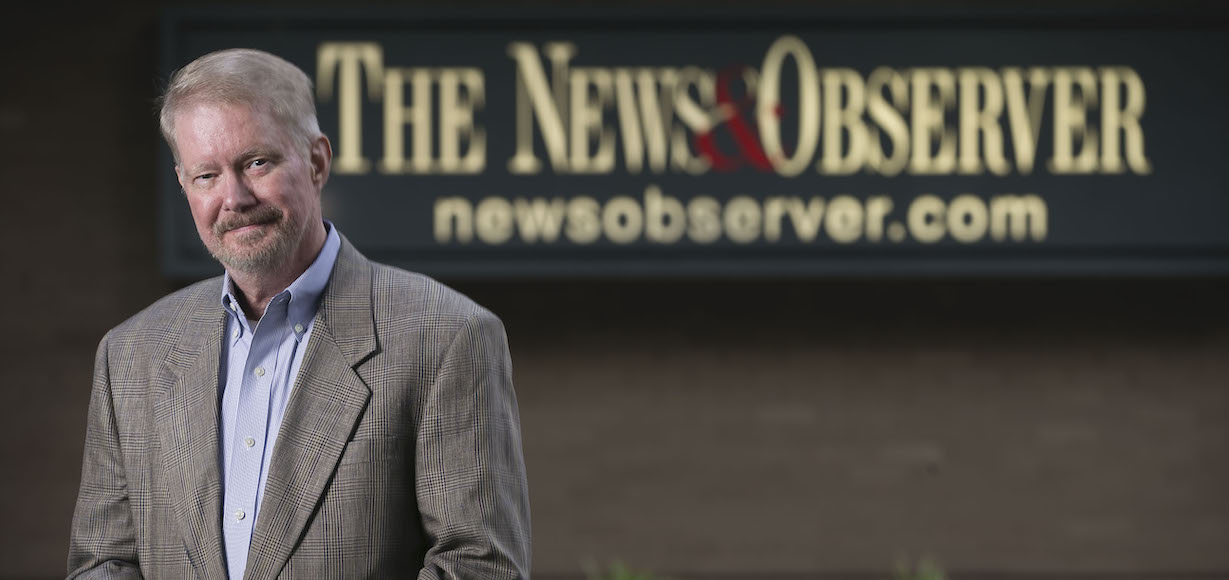 Rob Christensen in front of News and Observer sign