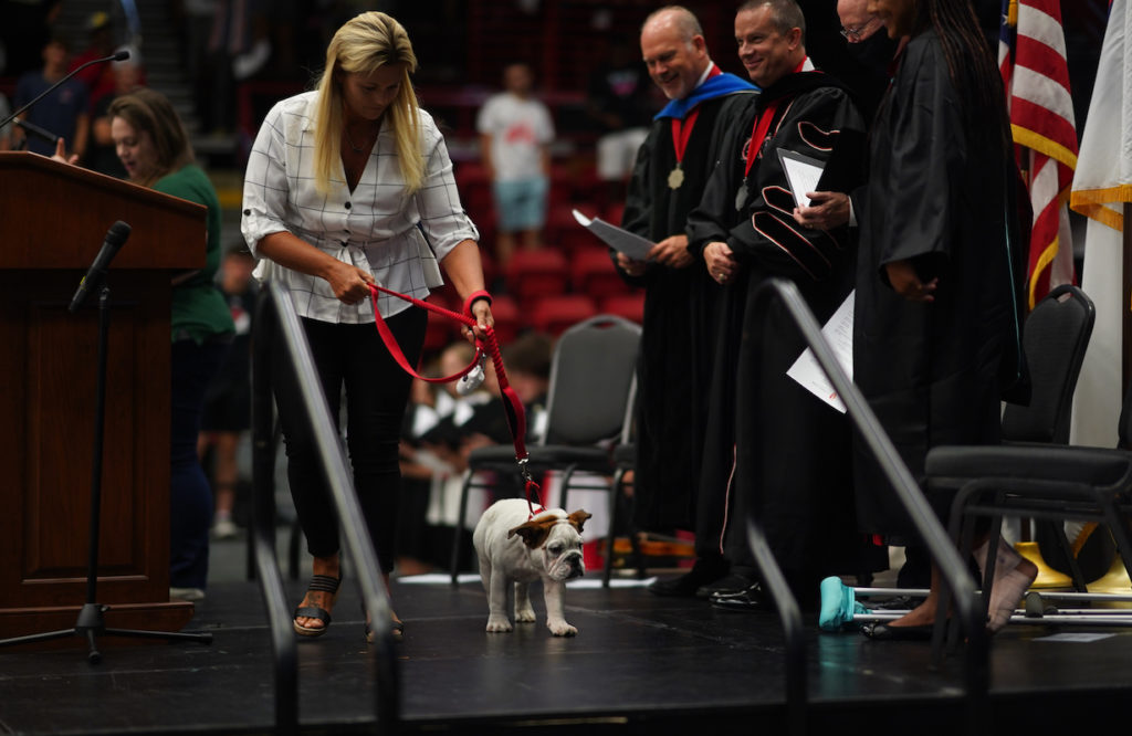 Ashley Chapman leads Bo on the stage at Convocation