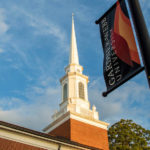 A photo of the steeple on Dover Chapel with a GWU banner in the foreground