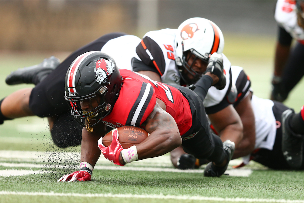 A Campbell football player tackles the Gardner-Webb player who is carrying the ball.