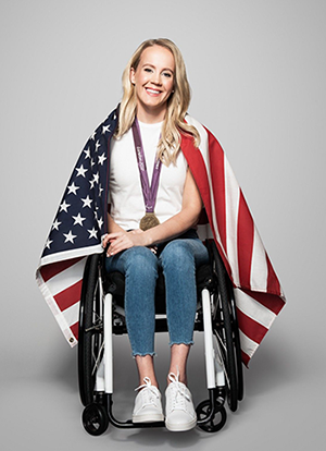 Mallory Weggemann with American flag draped over her shoulders