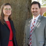 Associate Dean Jennifer Buckner and Dean Shawn Holt pose in front of a tree on the GWU Campus