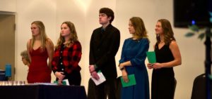 The five officers of Alpha Sigma Chi stand on stage during the induction ceremony