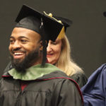 A student receives a hood during graduation.