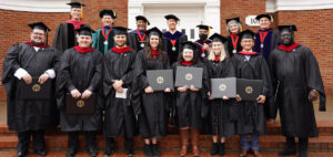 A group of divinity school graduates and professors pose after graduation in December 2021