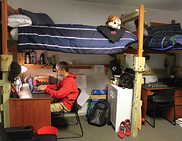 Male Student on computer in dorm room at Lutz Yelton Dorm