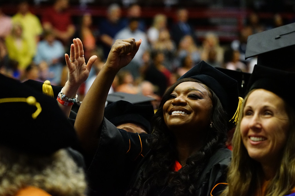 a graduate waves to the crowd