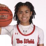 L'Mia Littlejohn in a basketball uniform, holding a basketball