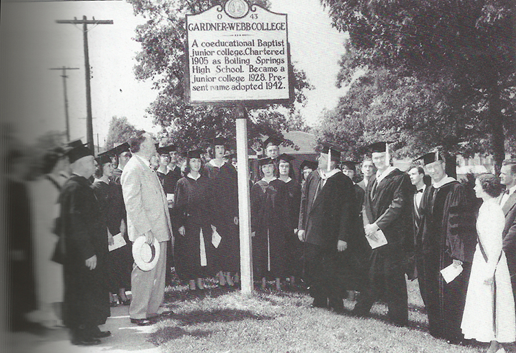 A group of people gathered around the historical marker for Gardner-Webb College
