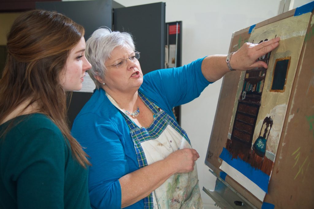 Susan Bell, right, talks to a student about her painting.