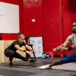 a woman and man exercising in the Crossfit room at GWU