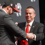 Dr. Downs right presents new VP and Director of Athletics Andrew Goodrich with GWU Swag