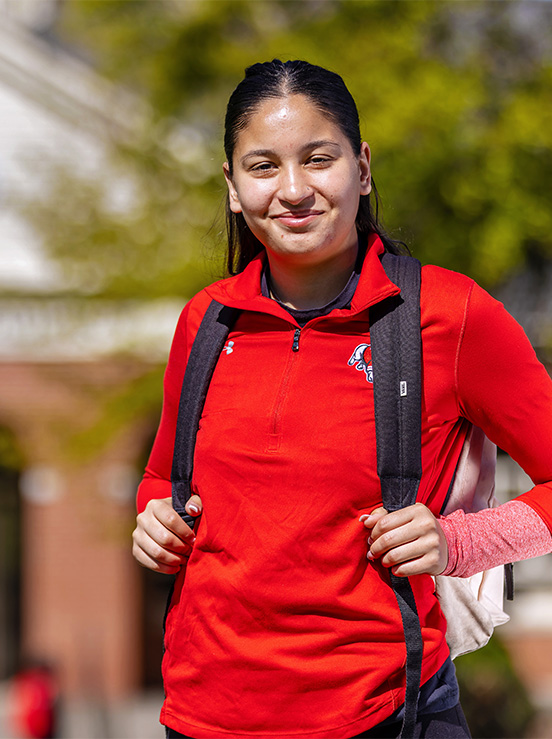 Female student walking to class, poses for photo
