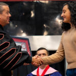 A student accepts her plaque from GWU President Dr. William M. Downs.