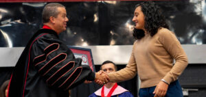 A student accepts her plaque from GWU President Dr. William M. Downs.