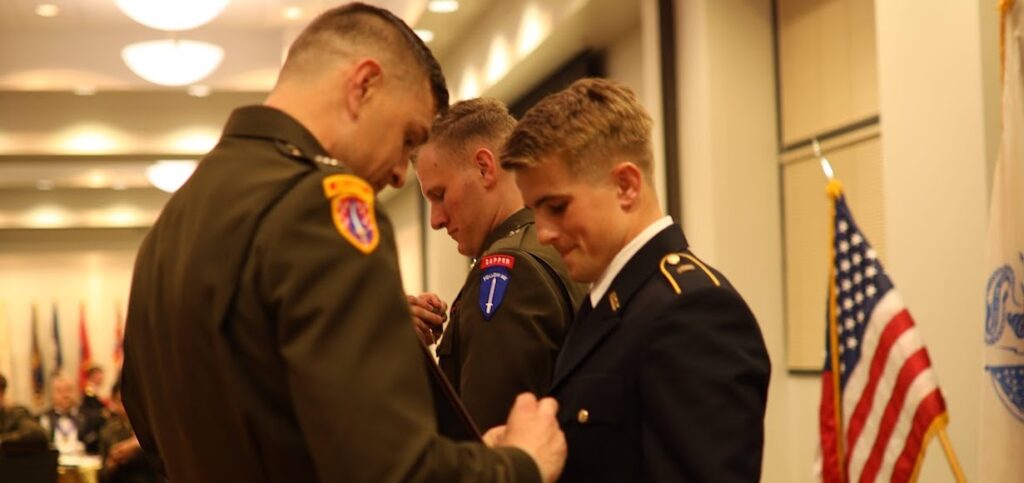 Cadet Parker Corwin receives a pin from an officer