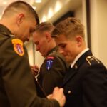 Cadet Parker Corwin receives a pin from an officer