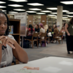 A student asks for help from a person in the poverty simulation
