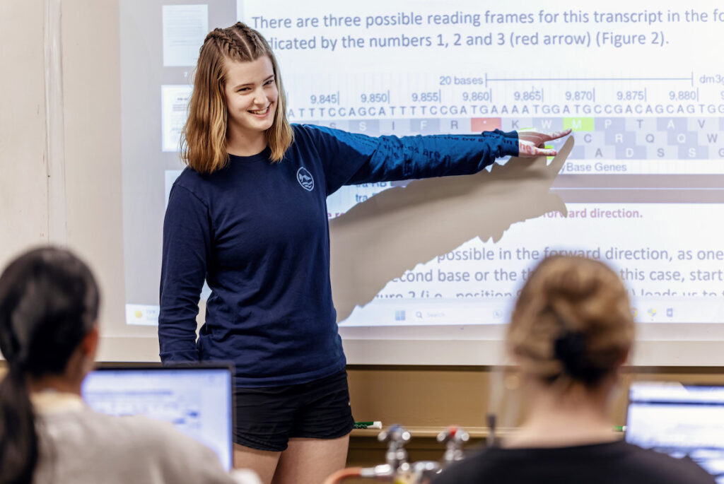 A student points to the board as she gives a presentation in science class 