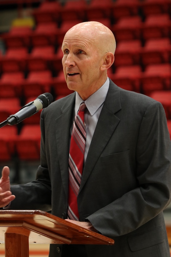 Chuck Burch stands at a podium in 2018