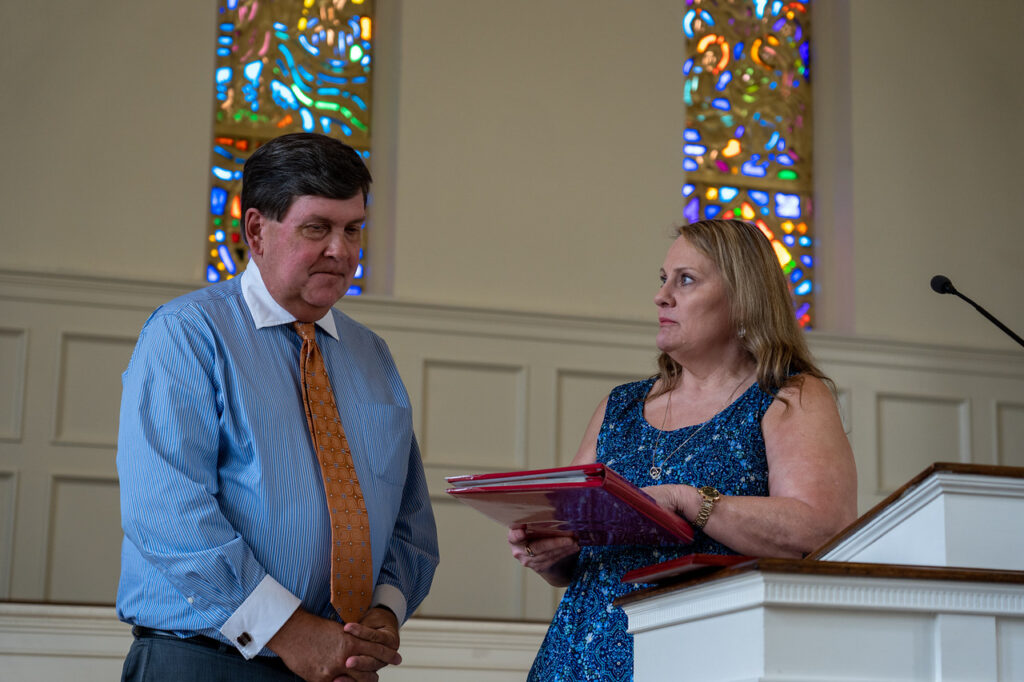Angie Green presents a momento to Dr. Danny West at the podium in Dover Chapel.