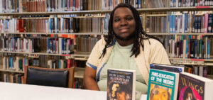 Brandon Richmond poses with his books in the library