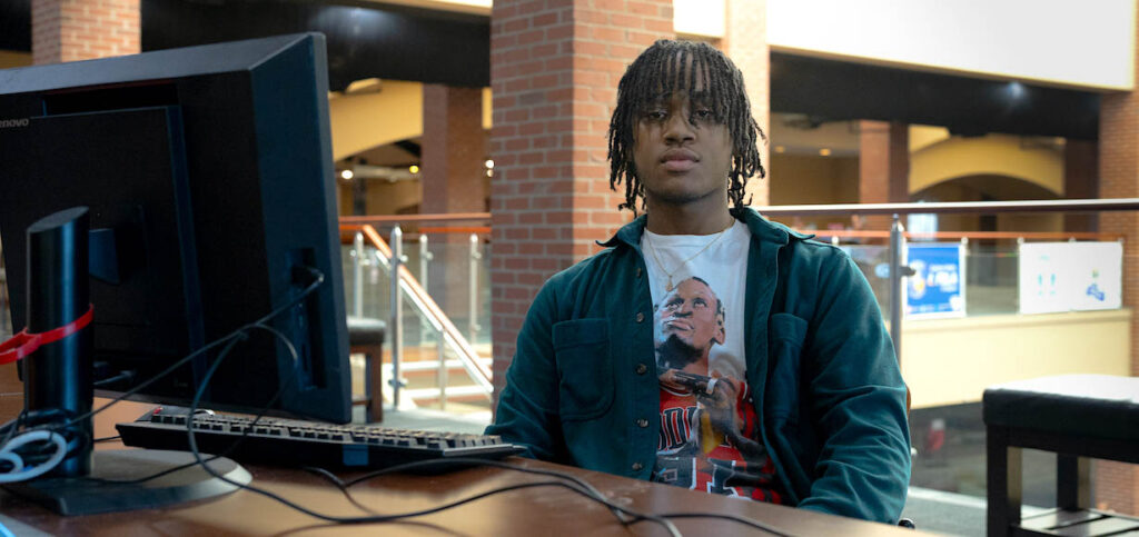 A photo of Issa Cogdell sitting in front of his computer in Tucker Student Center