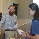 a male and two females talking in Blanton Auditorium about his business, Firebeard Coffee Roasters